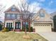 Charming two-story brick and siding home with a well-maintained front yard and two-car garage at 318 S Bend Dr, Durham, NC 27713