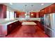Gourmet kitchen with cherry cabinets, granite countertops, stainless steel appliances, and center island at 318 S Bend Dr, Durham, NC 27713