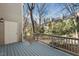 Wood deck with access to exterior storage closet, showing wooded backyard and adjacent townhomes at 3213 Coachmans Way, Durham, NC 27705