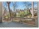 View of the rear of the property from the wood deck, with wooded scenery and neighboring townhomes at 3213 Coachmans Way, Durham, NC 27705