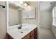 Well-lit bathroom featuring a white vanity, wooden cabinets, and a large mirror at 3213 Coachmans Way, Durham, NC 27705