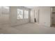 Bright bedroom featuring neutral carpet, two windows, and access to the bathroom at 3213 Coachmans Way, Durham, NC 27705