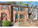 Brick townhome featuring green shutters and a well-maintained front lawn at 3213 Coachmans Way, Durham, NC 27705