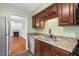 Well-lit kitchen boasts granite counters, wood cabinetry, and stainless steel appliances at 3213 Coachmans Way, Durham, NC 27705