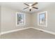 Bedroom featuring neutral walls, carpet, a ceiling fan, and two windows at 328 Cleveland St, Rocky Mount, NC 27803