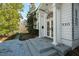 Elegant front entrance featuring a column-framed doorway, stone steps, and professional landscaping at 330 Tenney Circle, Chapel Hill, NC 27514