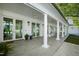 Covered porch with white columns, rocking chairs, ceiling fans, and views of the front yard at 330 Tenney Circle, Chapel Hill, NC 27514