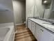 Bathroom featuring a double vanity with granite countertops, bathtub, and walk-in shower at 343 Magnolia Run Way, Benson, NC 27504