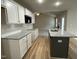 Modern kitchen featuring an island, white cabinets, granite countertops, and open view to living room at 343 Magnolia Run Way, Benson, NC 27504