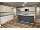 Beautiful kitchen featuring a gray island, modern appliances, white cabinets and plank flooring at 343 Magnolia Run Way, Benson, NC 27504