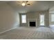 Spacious living room with a fireplace, neutral carpet, ceiling fan, and a door to the outside at 343 Magnolia Run Way, Benson, NC 27504