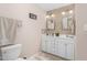 Bright bathroom featuring dual sinks, mosaic tile backsplash, and white cabinetry at 3743 Tartan Ln, Burlington, NC 27215