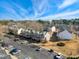 Aerial view of townhomes with parking, landscaping, and inviting exteriors, complemented by a clear blue sky and sparse trees at 3931 Volkswalk Pl, Raleigh, NC 27610