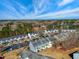 Aerial view of colorful townhomes, showcasing the community's appealing design, parking spaces, bare trees, and serene sky at 3931 Volkswalk Pl, Raleigh, NC 27610