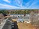 Aerial shot of charming townhomes with parking area and sparse trees under clear sky, showcasing community appeal at 3931 Volkswalk Pl, Raleigh, NC 27610