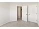 Neutral-toned bedroom with carpet and trim featuring an open doorway and double closets at 3931 Volkswalk Pl, Raleigh, NC 27610