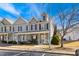 Charming townhome featuring a covered front porch, neutral siding, and black shutters, set against a bright blue sky at 3931 Volkswalk Pl, Raleigh, NC 27610