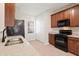 Modern kitchen featuring granite countertops, wooden cabinets, and black appliances near a pantry at 3931 Volkswalk Pl, Raleigh, NC 27610