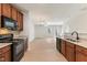 Open kitchen view showcasing granite counters, wood cabinets, and seamless flow to the living area at 3931 Volkswalk Pl, Raleigh, NC 27610