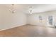 Spacious living room featuring wood flooring, ceiling fan, chandelier, and a door leading to the outside at 3931 Volkswalk Pl, Raleigh, NC 27610