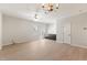 Spacious living room featuring wood flooring, ceiling fan, chandelier, and custom built-in cabinetry at 3931 Volkswalk Pl, Raleigh, NC 27610