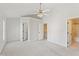 Bright main bedroom with neutral paint, carpet, ceiling fan, and multiple doors to ensuite bath at 3931 Volkswalk Pl, Raleigh, NC 27610
