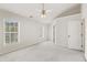 Bright main bedroom with carpet, ceiling fan, large windows, and neutral paint at 3931 Volkswalk Pl, Raleigh, NC 27610