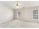 Expansive main bedroom with carpet, ceiling fan, and ample natural light from two windows at 3931 Volkswalk Pl, Raleigh, NC 27610