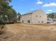 A spacious backyard featuring a large lawn, mature trees, and the home's siding at 4207 Hampstead Village Dr, Durham, NC 27703