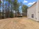 A spacious backyard featuring a large lawn, mature trees, and the home's siding at 4207 Hampstead Village Dr, Durham, NC 27703