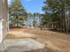 The backyard features a large lawn, a concrete patio, and several large trees for shade at 4207 Hampstead Village Dr, Durham, NC 27703