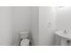 This half bathroom features a pedestal sink and a toilet at 4207 Hampstead Village Dr, Durham, NC 27703