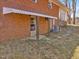 Backyard view of a brick house with a covered patio and minimal landscaping at 427 Watson Rd, Efland, NC 27243
