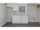 Basement sink with gray countertops, white cabinets, and a window providing natural light at 427 Watson Rd, Efland, NC 27243
