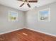Bedroom featuring hardwood floors, two windows for natural light, and ceiling fan at 427 Watson Rd, Efland, NC 27243