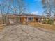 Single-story brick house with a covered carport and front porch, set in a lush landscape under a clear blue sky at 427 Watson Rd, Efland, NC 27243