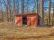 Weathered shed surrounded by trees and fall foliage, with open doorway and rustic charm at 427 Watson Rd, Efland, NC 27243