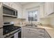 Well-lit kitchen with stainless steel appliances, granite countertops, and ample cabinet space at 4705 Blue Bird Ct # C, Raleigh, NC 27606