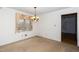 Dining room features neutral walls and carpet, classic chandelier, and window at 6312 New Market Way, Raleigh, NC 27615