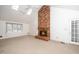 Bright living room boasts a brick fireplace, skylights, and neutral carpeting at 6312 New Market Way, Raleigh, NC 27615