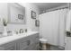 Bright bathroom with vanity, gray cabinets, sleek mirror, and shower and tub at 642 Thistle Dr, Burlington, NC 27217