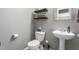 Cozy powder room featuring pedestal sink, sleek shelving and modern fixtures at 642 Thistle Dr, Burlington, NC 27217