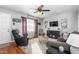 Inviting living room featuring hardwood floors, comfortable seating, a stylish rug, and large windows at 642 Thistle Dr, Burlington, NC 27217