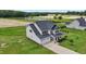 Aerial view showcases the home, lush green lawn, pond and agricultural fields, highlighting the property's serene setting at 6804 Arlington Oaks Trl, Raleigh, NC 27603