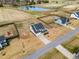 Scenic aerial view of property showcasing large lot, pond, and a home with a backyard play area at 6804 Arlington Oaks Trl, Raleigh, NC 27603