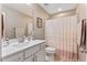Cozy bathroom features a shower-tub combo, white vanity with a mirror, and neutral wall color at 6804 Arlington Oaks Trl, Raleigh, NC 27603