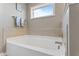 Modern white bathtub with tile accent and window above at 6804 Arlington Oaks Trl, Raleigh, NC 27603