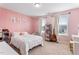 Bright bedroom features pink walls, neutral carpet, and natural light from two windows with a guitar at 6804 Arlington Oaks Trl, Raleigh, NC 27603