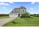 Charming two-story home featuring a manicured front lawn, a three car garage and a welcoming front porch at 6804 Arlington Oaks Trl, Raleigh, NC 27603