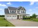 Inviting two-story home with a three-car garage, covered porch, and meticulously maintained front yard at 6804 Arlington Oaks Trl, Raleigh, NC 27603